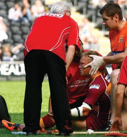 Huddersfield's Luke Robinson receives treatment on the field against Hull FC at the start of July